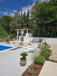 a patio with two white chairs and a gazebo at Villa Krivokapic in Trebinje +27 photos