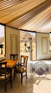 a dining room with a wooden table and chairs at WADI RUM DESERt MOON in Wadi Rum