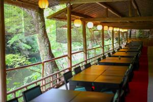 a row of tables and chairs in a room with trees at Momijiya Annex in Kyoto +81 photos