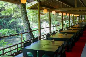 a row of tables in a room with trees at Momijiya Annex in Kyoto