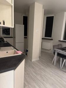a kitchen with a white refrigerator and a table at Modern & Quiet Apartment in Chişinău +6 photos
