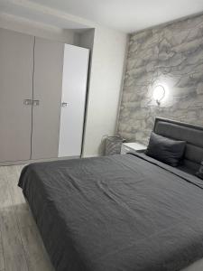 a bedroom with a large bed and a stone wall at Modern & Quiet Apartment in Chişinău