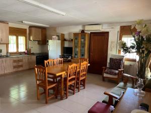 a kitchen and dining room with a wooden table and chairs at Mas d'Arturo in Serós