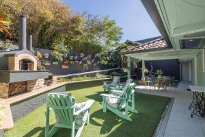a patio with chairs and a table and a fireplace at Silver Waters | Private Cove | Ocean Views in Zilzie