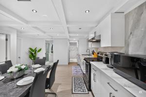 a kitchen with a table and a dining room at Modern and spacious 3-BR basement suite in Vancouver