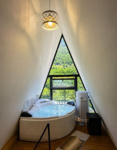 a bathroom with a large tub in a attic at Arditi's Chalets in Bogë