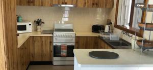 a small kitchen with a stove and a microwave at Milbanksea in Portland +9 photos