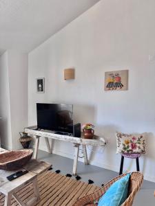 a living room with a table with a television at Casa das Portas de Évora in Estremoz