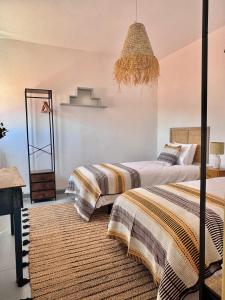 a bedroom with two beds and a chandelier at Casa das Portas de Évora in Estremoz