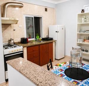 a kitchen with a white refrigerator and a counter top at Depto rep del libano 11 capacidad 5 personas in La Banda +4 photos