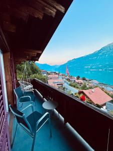 a balcony with chairs and a view of the water at Chalet Luna - Alpine Apartment by Lake Brienz in Niederried
