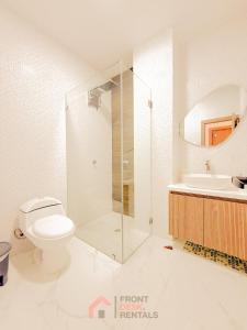 a bathroom with a shower and a toilet and a sink at Beachfront pool whirlpool & firepit in Montañita