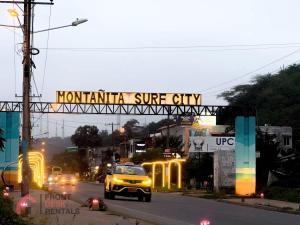 a yellow car driving under a sign that reads montana supreme city at Beachfront pool whirlpool & firepit in Montañita