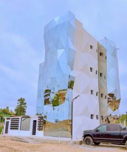 a building with a geometric facade with a car parked in front at Beachfront pool whirlpool & firepit in Montañita +37 photos