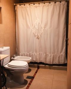 a bathroom with a toilet and a shower curtain at Canto a Jujuy - Yala in Yala
