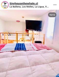 a bedroom with a bed with a computer monitor on it at The whale in Guaquen