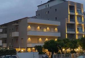 a large building with a parking lot in front of it at EMERALD Suites Cervia in Cervia
