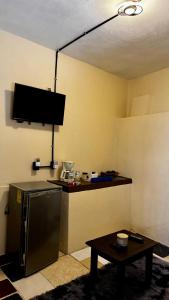 a kitchen with a counter with a refrigerator and a table at Loft Industrial con fogatero in Mineral del Monte