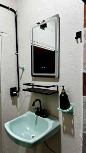 a bathroom with a sink and a mirror on a wall at Loft Industrial con fogatero in Mineral del Monte
