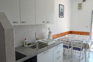 a kitchen with white cabinets and a sink and a table at Apartment Grscica 4487a in Prizba