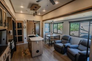 a tiny house with a kitchen and a living room at Ouachita Outpost RV Park in Hodgen