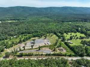 an aerial view of a farm with mountains in the background at Ouachita Outpost RV Park in Hodgen