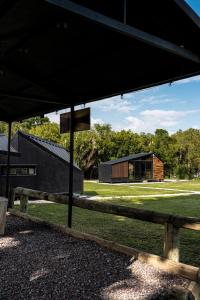 a black barn with a wooden fence and a building at Rosalia Haras Glamping - Experiencia ecuestre in Atlixco