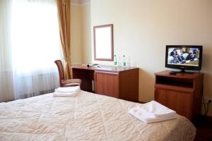 ノヤブリスクにあるEuropa Hotelのベッドとテレビが備わるホテルルームです。