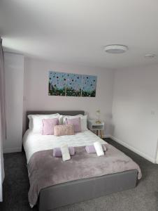 a bedroom with a bed with purple and pink pillows at Stylish town flat in Bude, with secure parking in Bude +20 photos
