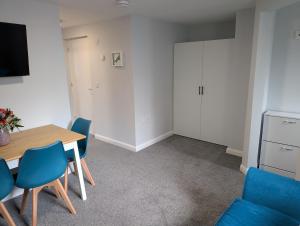 a dining room with a table and blue chairs at Stylish town flat in Bude, with secure parking in Bude