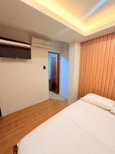ein Schlafzimmer mit einem weißen Bett und einem Fenster in der Unterkunft Hotel Riomar in Iquitos