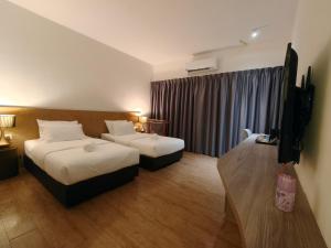 a hotel room with two beds and a window at SF Roomstay Tunjong in Kota Bharu