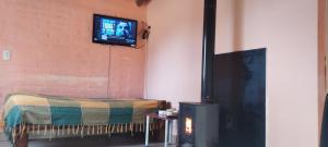 a living room with a tv on the wall at La Nave del Olvido- Cabaña Potrerillos in Potrerillos