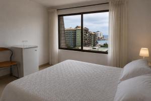 a bedroom with a bed and a window with a view at Hotel Carande, Papudo in Papudo
