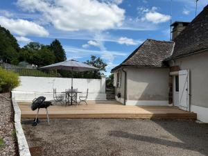 a patio with a table and an umbrella at Maison de Lili - Spacieuse in Beynat