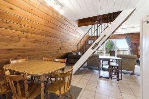 a dining room with a table and a staircase at Chalet #25 in Stevensville