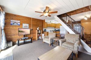 a living room with wooden walls and a ceiling fan at Chalet #25 in Stevensville