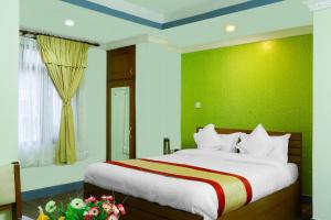 1 dormitorio con 1 cama grande y pared verde en Kathmandu Garden Home, en Katmandú