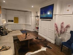 a living room with a table and a tv on the wall at Double rooms in shared house in Bournemouth
