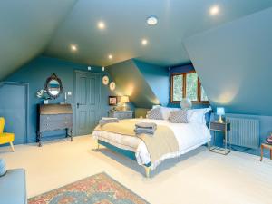 a bedroom with blue walls and a large bed at River Test View in Chilbolton