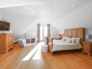 a bedroom with a bed and a tub and a sink at High View House in Kemeys Inferior