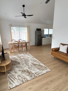 a living room with a table and chairs and a rug at Hildas Villa in Arorangi