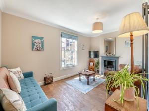 a living room with a blue couch and a fireplace at 4 Smiddy Hill in Pickering +11 photos