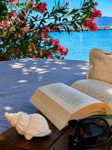 a book and a seashell and glasses on a table at Porto Evia Boutique Hotel in Amarynthos +101 photos