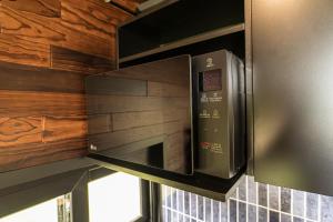 a microwave oven in a kitchen with wooden walls at Rosalia Haras Glamping - Experiencia ecuestre in Atlixco