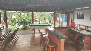 a patio with a pool table and a grill at Hotel E Pousada do Patrão in Bataguaçu