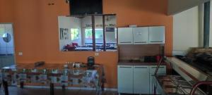 a kitchen with white cabinets and a table at Hotel E Pousada do Patrão in Bataguaçu