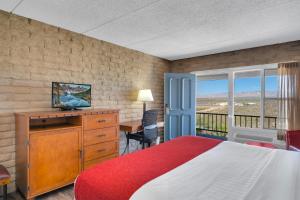 a bedroom with a bed and a desk with a television at Tombstone Lookout Lodge, SureStay Collection by Best Western in Tombstone +27 photos