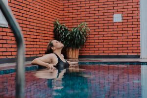 a woman is sitting in a swimming pool at Airport Transit Villa in Minuwangoda