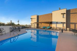 a swimming pool with chairs and a building at Tombstone Lookout Lodge, SureStay Collection by Best Western in Tombstone